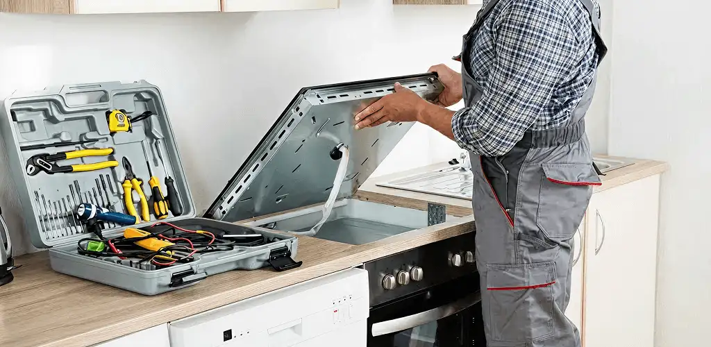 Handyman repairing a cooktop and checking wiring connections in Yonkers, NY