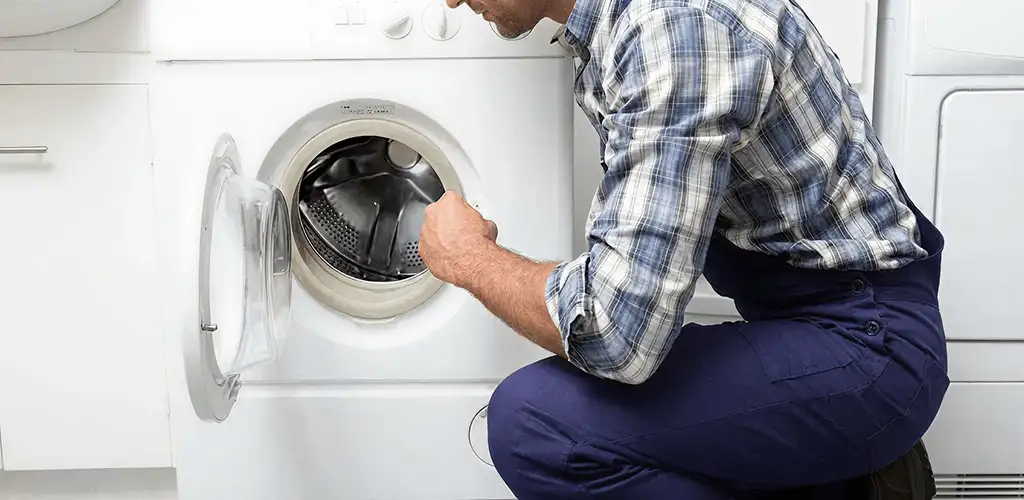 Handyman inspecting a dryer drum and internal parts for repair in Yonkers, NY