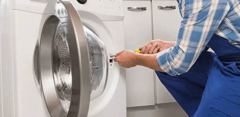 Handyman repairing a clothes dryer and checking electrical connections in Yonkers, NY