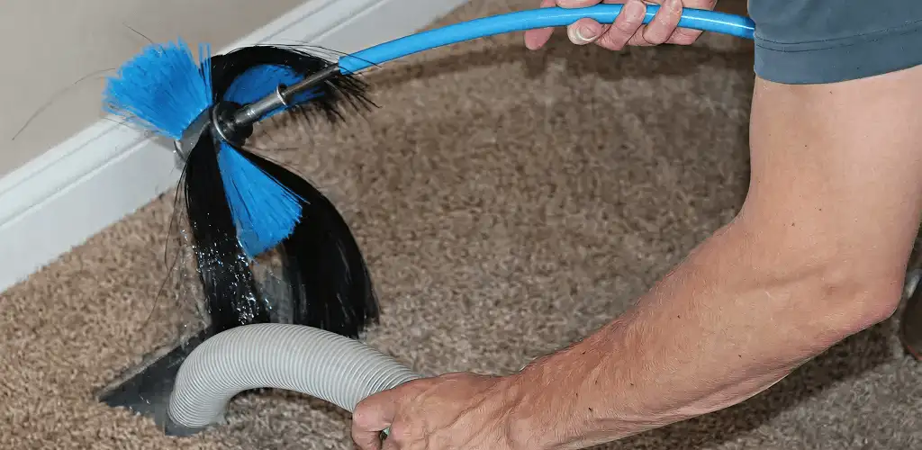 Dryer vent cleaning technician brushing lint from a vent line in Yonkers, NY
