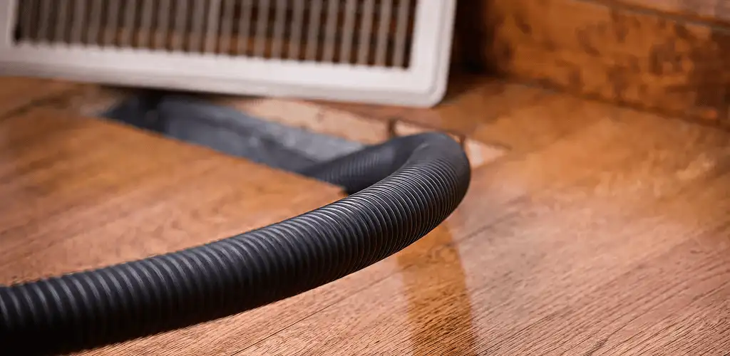 Air duct cleaning hose inserted into a floor vent for ductwork cleaning in Yonkers, NY