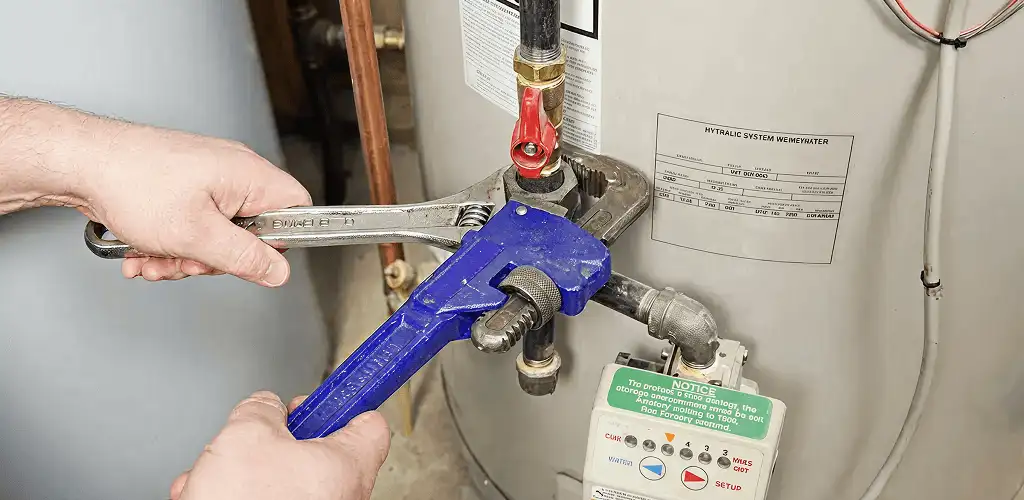 Water heater repair technician tightening the shutoff valve and supply line in Yonkers, NY